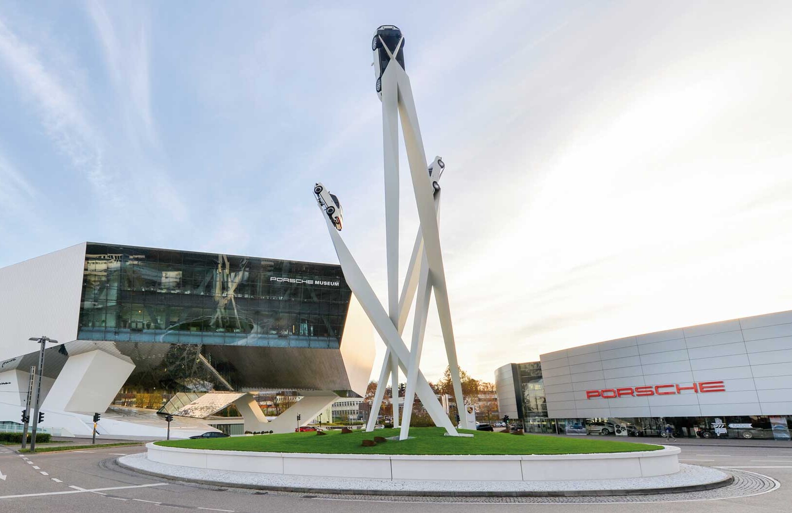 Blick auf das Porsche Museum und das Kunstwerk „Inspiration 911“ auf dem Kreisverkehr. Die drei Stelen tragen an ihren Spitzen in bis zu 24 Metern Höhe je einen Porsche 911.